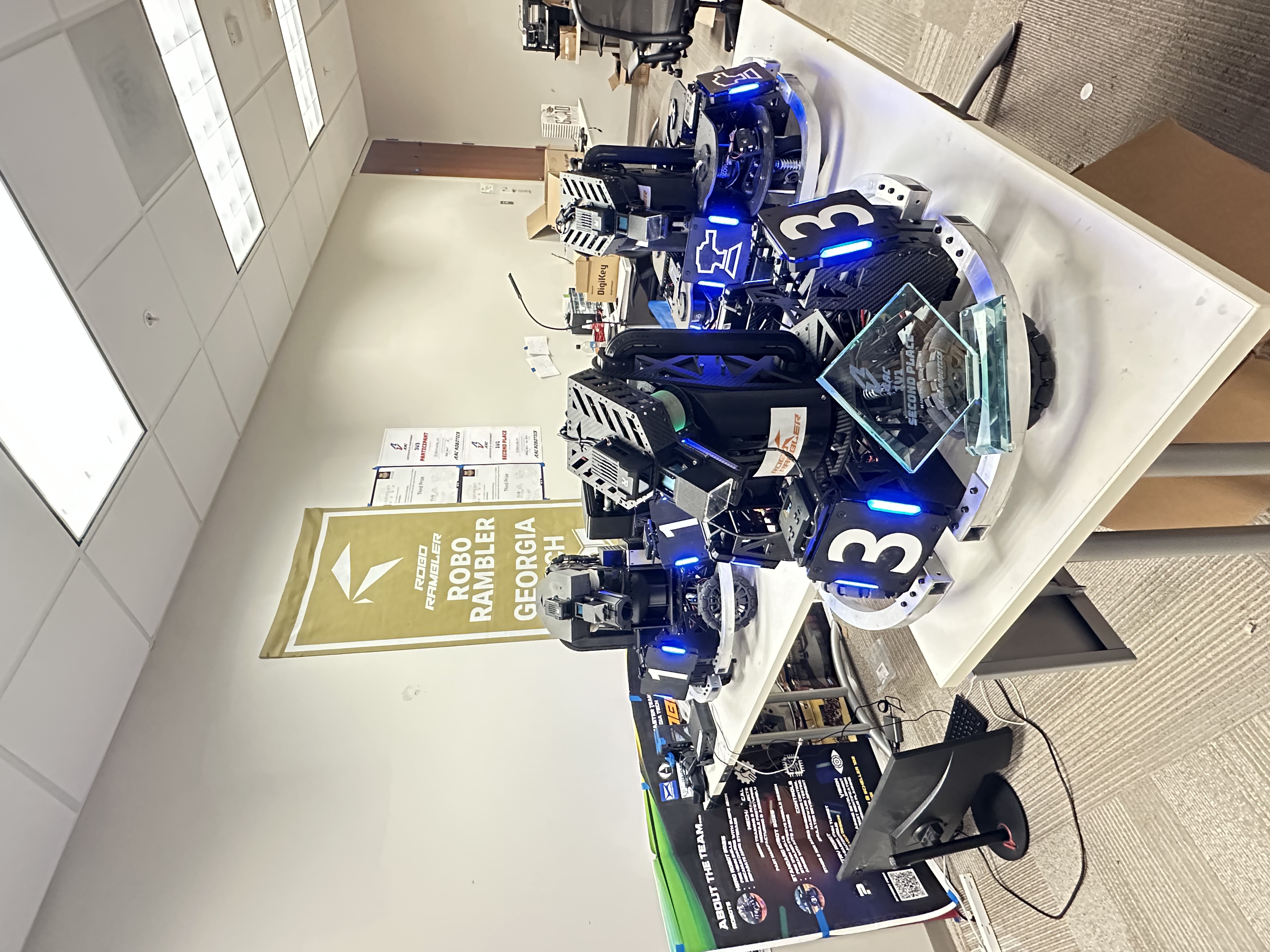 ARCC 2026 robot fleet with trophy at headquarters